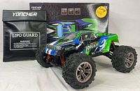 Blue and green Yoncher Spirit RC monster truck displayed with original box and LiPo guard bag