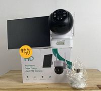 Solar-powered HD PTZ security camera displayed on top of its packaging box, showing solar panel, camera, and mounting bracket.