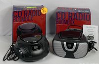 Two Proscan CD Radio Boomboxes with packaging and accessories including power cords and user manual.