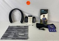 Wireless neck fan, sleep headband headphones in box, reusable earplugs, USB charging cable, and black and white patterned bag shown on white background