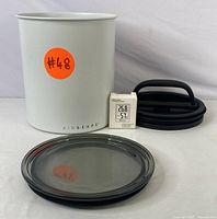 Airscape coffee canister with detached airtight lid, inner lid and digital monitor displayed separately to show all components.