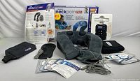Complete therapy kit displayed including massager, pads, neck cushion, belt, gel, and spray bottle