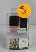 Proscan Bluetooth Smartwatch in clear packaging, showing rose gold watch and additional black wristband inside box.