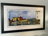 Framed artist proof print hanging on wall, showing rural landscape scene with buildings and fence.
