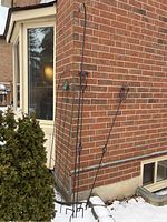 Full view of garden trellis leaning against brick wall, showing height and structural design.