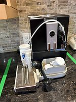 Overall view of coffee machine with accessories arranged around it