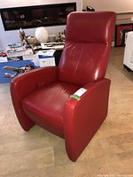 Front angle of red leather reclining chair showing padded armrests, seat, and backrest, with visible side recliner lever.
