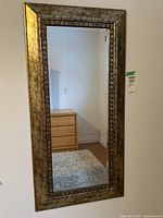Front view of the wall mounted framed mirror showing the whole mirror and frame.