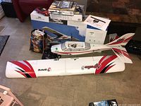 Full view of Safe radio control model airplane disassembled with wing off alongside boxes and other lot items