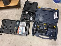 Photo showing the Mastercraft cordless drill, portable air compressor, and Black & Decker drill kits all in their respective carrying cases.