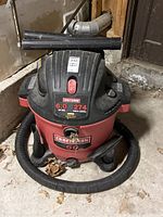Overall view of the Craftsman shop vacuum showing the main unit with hose coiled at base and extension tubes on top.
