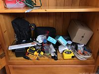 Photo of assorted tools including screwdrivers, measuring tape, tool bags, cables, boxed Nest x Yale Lock, and a black Autel Autolink case.
