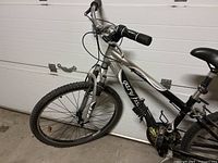 Front side view of Gary Fisher Capitola black and silver mountain bike with knobby tires and handlebar grips.