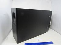 Side view of black Bose subwoofer speaker with a ruler for scale.