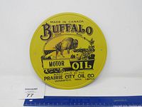 Front view of the yellow round Buffalo Motor Oil metal sign showing the buffalo graphic and company text.