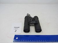 Front view of Bushnell binoculars with ruler for size reference