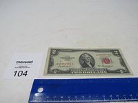 Front view of 1953 A red seal two dollar bill with ruler for scale