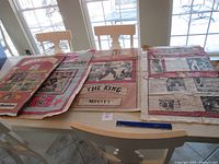 Four large used Elvis Presley posters spread out on a table, showing different designs and imagery related to Elvis Presley.