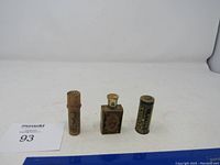 Front view of all three vintage containers with a ruler for scale.