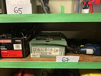Shelf view showing Craftsman angle grinder box and green soldering gun box side by side, labeled 65 and 67.