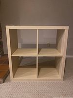 Front view of the 4-compartment shelving unit showing four square shelves in a 2x2 configuration