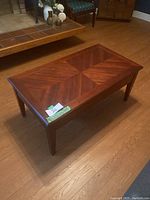 Front angle view of wooden lift-top coffee table showing wood grain pattern on top.