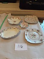Various angles of five vintage decorative plates and dishes on white background showing floral and gold trim details