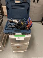Mastercraft hammer drill and case on top of three drawer plastic storage unit