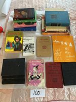 Overview photo showing 17 books of various titles, sizes, and colors arranged on a fabric surface, including colorful children's books and reference guides.