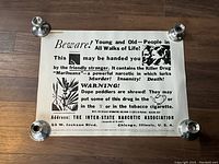 Full view of vintage Beware of Marihuana poster with candleholders at corners, showing complete text and imagery.