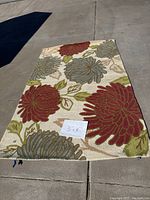 Full view of the 5x8 multicolor wool area rug with floral pattern laid out on concrete floor showing overall size and design.