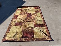 Full view of the 5'x8' carpet laid out on concrete ground showing the full multicolored patchwork pattern.