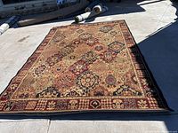 Full view of the 10’10” x 7’8” area rug laid out showing overall condition and pattern.