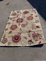Rectangular colorful floral pattern 4'x6' wool rug laid out on concrete surface showing the full pattern and size.