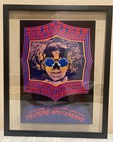 Framed psychedelic concert poster showing full front side in black frame.