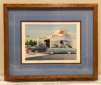 Framed lithograph with blue mat and wooden frame showing classic cars and a Mobiloil gas station.