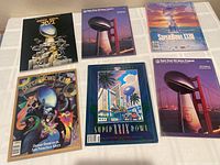Top view of six Super Bowl game programs arranged flat, showing front covers.