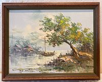 Framed oil painting of a fishing scene showing boats, structures on water, and a tree on the shoreline.