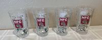 Set of four clear heavy 16 oz beer glasses decorated with San Francisco 49ers NFC Champions logos and silver crackle patterns arranged side by side.