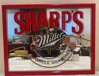 Front-facing view of the rectangular mirror showing Sharp's name in bold red letters and central Miller logo with text 'Non-Alcoholic Malt Beverage'.
