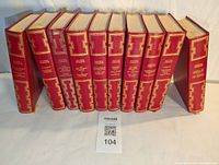 Side view of 10 red hardcover Agatha Christie books showing spine and gold decorative pattern