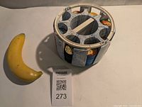 Photo of circular original chip holder with multiple stacks of poker chips inside, next to a banana for scale.