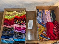 Two boxes showing bowties in various bright colors alongside ties with mixed patterns