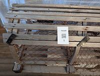 Close-up of lobster trap wooden slats and metal brackets showing wear and aged condition