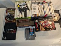 Top view of video games including NES cartridges, Xbox 360, PlayStation games, PC games, and additional items.