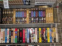 Top shelf showing Star Wars VHS tapes, Lord of the Rings, espionage themed and other movies with visible titles on VHS cases.