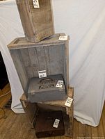 Five old wooden boxes stacked and arranged showing various sizes and conditions. Some have latches and handles, others are open crates.