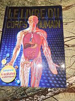 Front cover of the anatomy book displaying a detailed illustration of a human figure showing muscles, organs, and circulatory system with title in French.