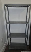 Front view of the IKEA Hylis silver metal shelving unit showing three shelves and sturdy frame.