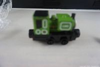 Green cast metal toy train named Luke Thomas with black wheels and white detail, viewed from the side.